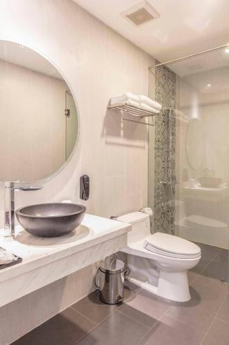 a bathroom with a sink and a toilet and a mirror at Len's Hotel in Da Lat