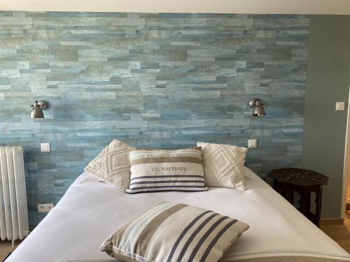 une chambre avec un lit avec un mur en pierre dans l'établissement La Maison du Vieux Port, à Flamanville