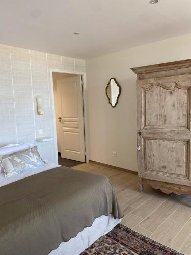 une chambre avec un lit et une armoire en bois dans l'établissement La Maison du Vieux Port, à Flamanville