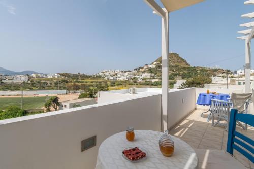 a balcony with a table and a view of the ocean at Vira Vivere Houses in Plaka Milou