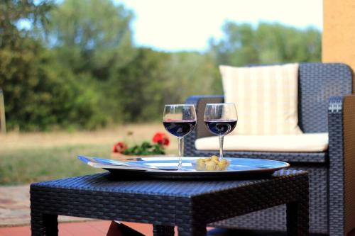 two glasses of red wine sitting on a table at Un'oasi di pace in riva al mare in Pittulongu