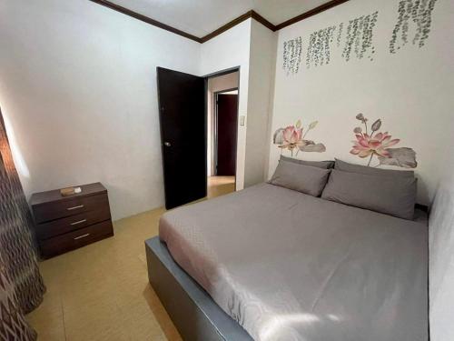 a bedroom with a bed and a dresser in it at Transient Home at Tierra Vista near SM Dasma with Wifi and Netflix in Mabatang