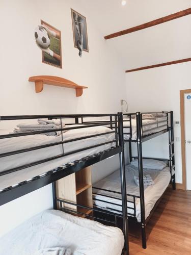 a room with two bunk beds in a room at Voyage Hostel - Rooms with Shared Kitchen in Douglas