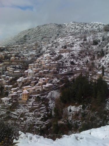 a town on a mountain covered in snow at Stonehouse dome Lagadia in Lagadia
