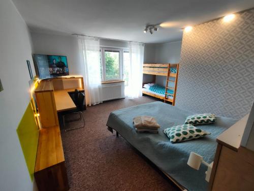 a bedroom with a bed and a bunk room with a desk at Kasztanowe Wrota in Kosewo