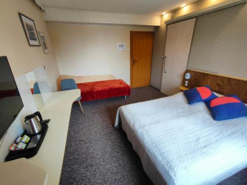 a hotel room with two beds and a desk at Kasztanowe Wrota in Kosewo