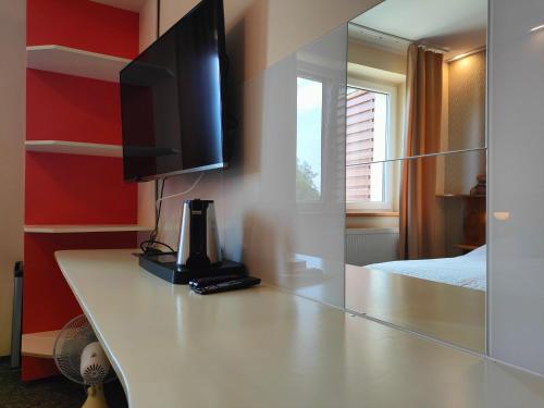 a room with a counter with a television and a bed at Kasztanowe Wrota in Kosewo