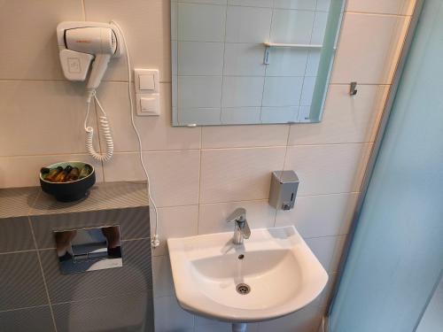 a bathroom with a sink and a mirror and a phone at Kasztanowe Wrota in Kosewo