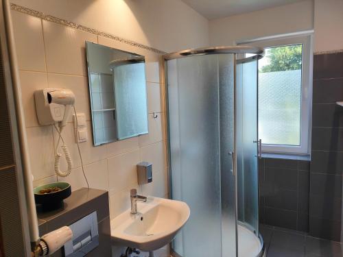 a bathroom with a shower and a sink at Kasztanowe Wrota in Kosewo