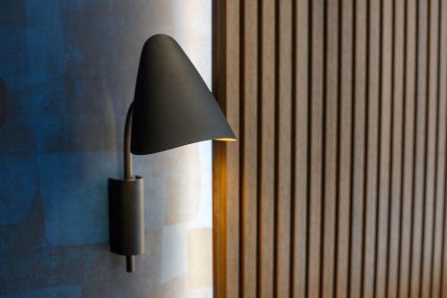 a black lamp sitting on the side of a wall at Dreamers' Rooms Sorrento in Sorrento