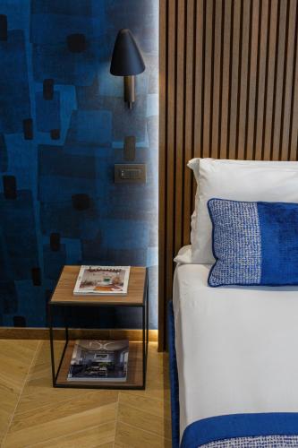 a bedroom with a bed and a table next to a bed at Dreamers' Rooms Sorrento in Sorrento