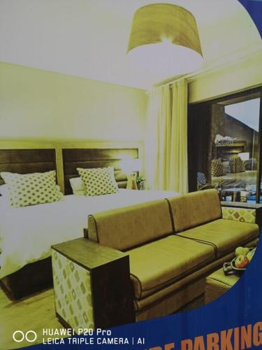a hotel room with a bed and a couch at Pearl Guest House Vanderbijlpark Johannesburg in Vanderbijlpark