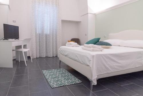 a bedroom with a bed and a desk and a television at Il vecchio arco in Novoli
