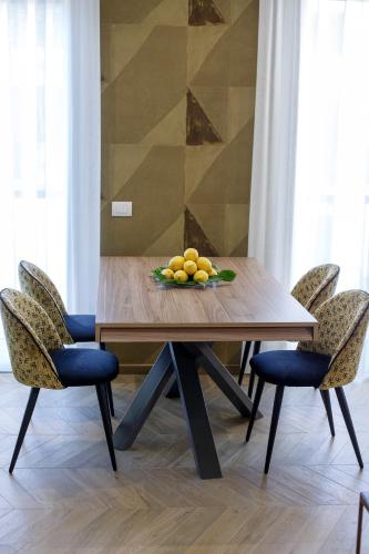 a wooden table with chairs and a bowl of fruit on it at Dreamers' Rooms Sorrento in Sorrento