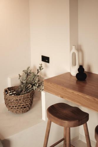 a desk with a stool and a vase with a plant at Om Living Afitos in Afitos