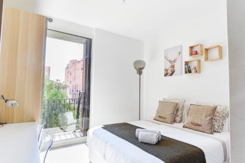 une chambre blanche avec un lit et un balcon dans l'établissement Casa Juturne 22, proximité Monaco, à Beausoleil