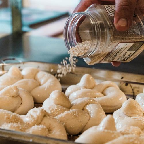 a person pouring food from a jar onto doughnuts at Pension Rokytka in Kryštofovo Údolí