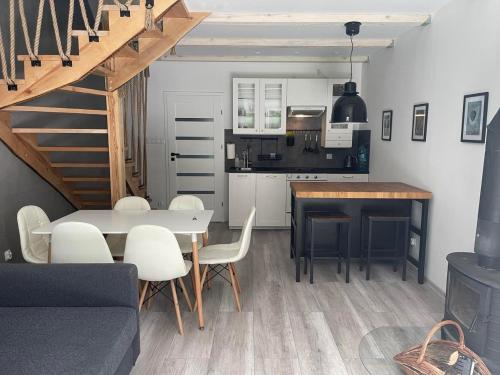 a kitchen and dining room with a table and chairs at Zakątek Wenantego Apartament in Kopalino
