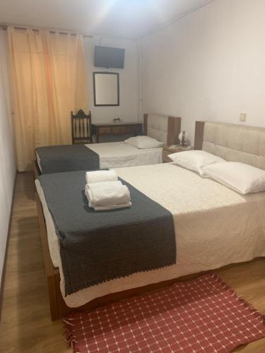 a bedroom with two beds with towels on them at Residencial Encontro in Vila Real