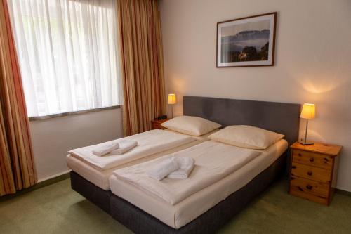 een slaapkamer met een bed met twee handdoeken erop bij Hotel garni Grundmühle in Bad Schandau