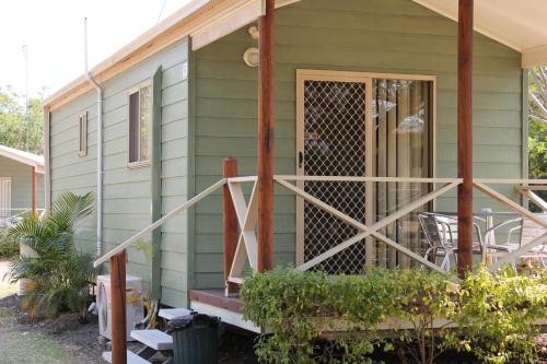 a green house with a screened in porch at Aussie Outback Oasis Holiday Park in Charters Towers