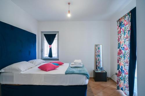 een slaapkamer met een bed met kussens en een raam bij Villa Luce in Itri