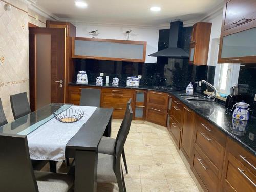 a kitchen with wooden cabinets and a table with chairs at Quinta dos Filipes in Palmela