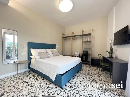 Schlafzimmer mit einem Bett, einem Schreibtisch und einem TV in der Unterkunft Interno Sei B&B in Agropoli