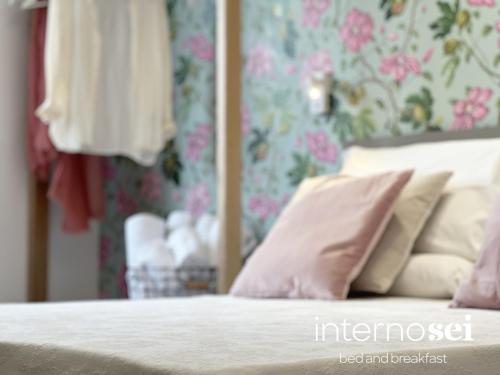 a bedroom with a bed with pink pillows on it at Interno Sei B&B in Agropoli