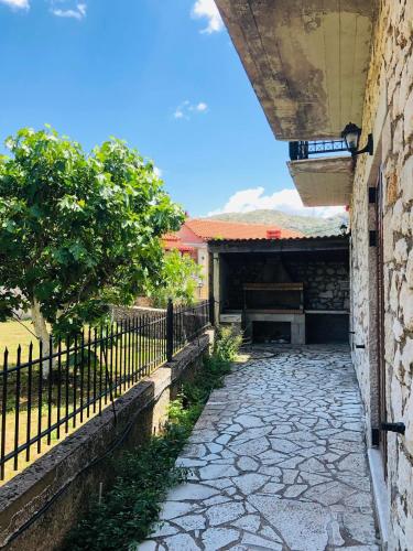 a stone walkway in front of a building with a fence at Stonehouse dome Lagadia in Lagadia