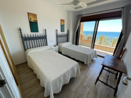 a room with two beds and a view of the ocean at Playa Marbella in Marbella