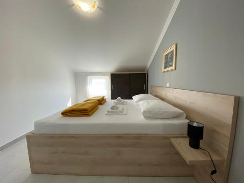 een slaapkamer met een groot bed met een houten hoofdeinde bij Emanuela 2 in Novalja