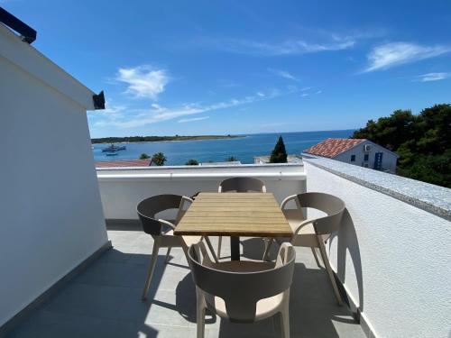 een houten tafel op een balkon met uitzicht op de oceaan bij Emanuela 2 in Novalja