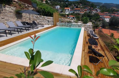 a swimming pool with a view of a villa at Gerês - Refúgio das Laranjeiras in Geres