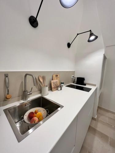 波利尼亞諾阿馬雷的住宿－Anfora dei Segreti - Suite Apartment，厨房水槽里放着一碗水果
