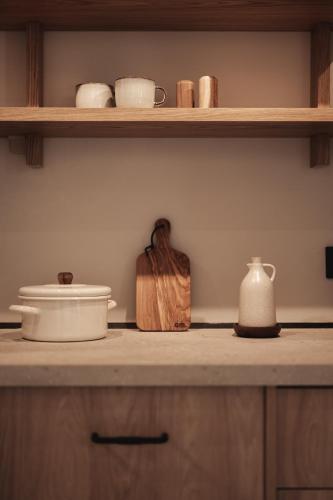 a kitchen counter with wooden shelves and pots and pans at Om Living Afitos in Afitos
