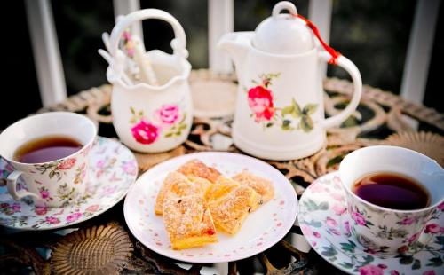 a table with plates of food and cups of tea at Starhome Cottage in Renai