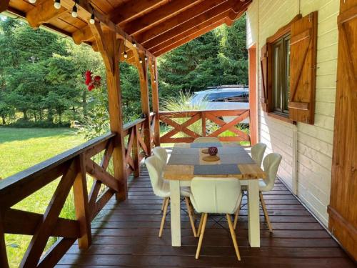 a wooden deck with a table and chairs on it at Zakątek Wenantego in Kopalino