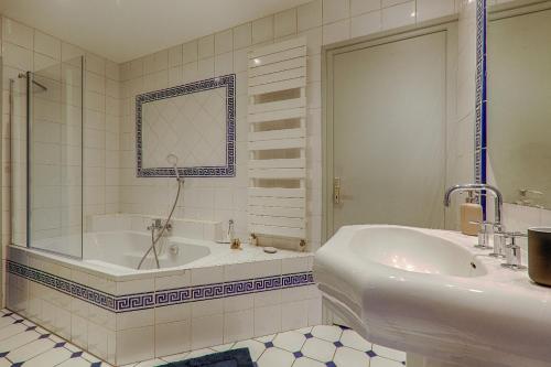 a white bathroom with a tub and a sink at La Ballerine - Baby foot - Centre historique in Romans-sur-Isère