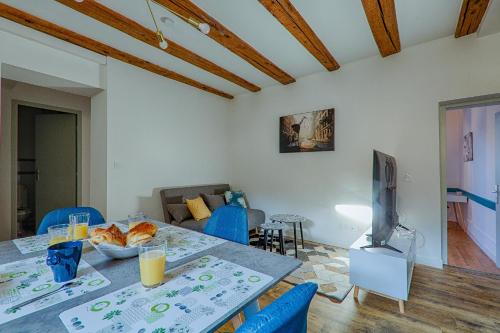 un salon avec une table et une télévision dans l'établissement La Ballerine - Baby foot - Centre historique, à Romans-sur-Isère