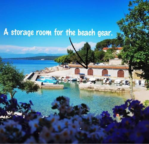 un almacén para el patio de la playa con las palabras y un almacén para la playa en Apartment Skaline en Malinska