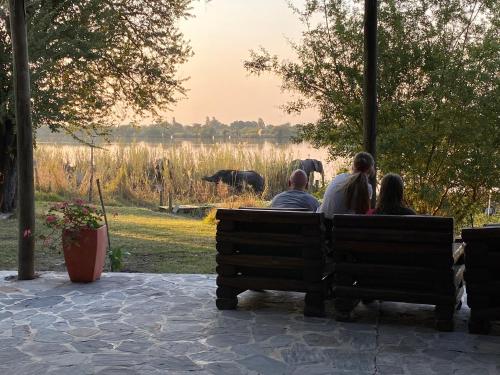a group of people sitting on a bench in a park at Big 5 Toro Lodge in Kasane