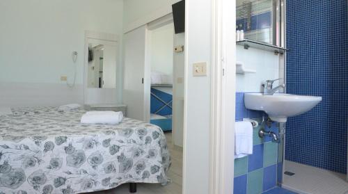 ein Bad mit einem Bett und einem Waschbecken in einem Zimmer in der Unterkunft Residence Hotel Amalfi in Lido di Savio