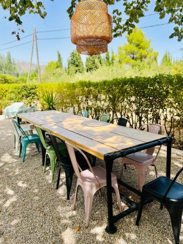 a wooden table with chairs and a basket hanging over it at Casa de Los Lirios in Muro de Alcoy