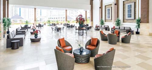 un hall avec des chaises et des tables dans un bâtiment dans l'établissement 1 BR Cozy Modern-Style Condo with Balcony & 5-star amenities at Wind Residences, à Tagaytay