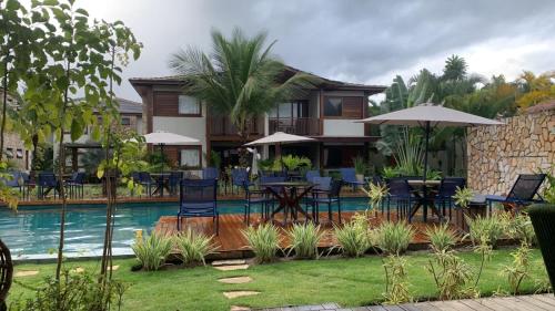バーハ・グランデにあるApartamento em barra grande - Villaggio di Mare - apto 02 bl 04 - Gardenのスイミングプール、テーブルと椅子が備わるリゾートです。