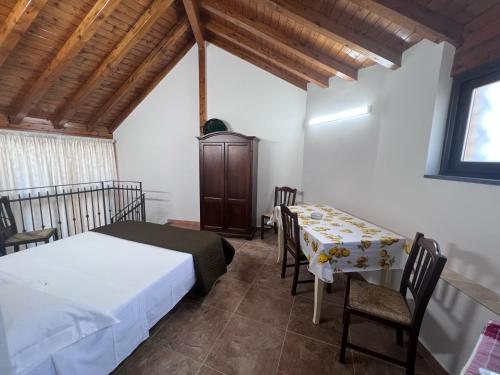 1 dormitorio con 1 cama, mesa y sillas en Esclusivo Cortile Duca D'Aosta ai piedi dell'ETNA, en Viagrande