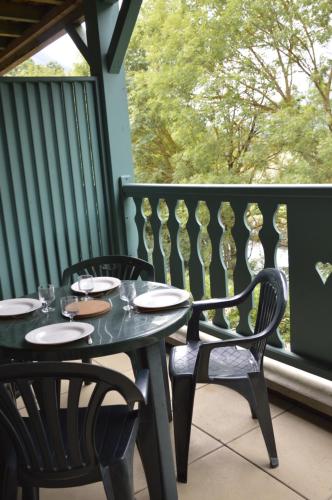 - une table et des chaises noires sur une terrasse couverte avec une fenêtre dans l'établissement Studio Confortable Au Coeur d'Arreau, à Arreau