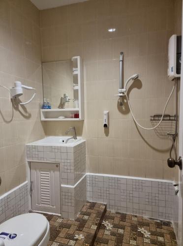 a bathroom with a toilet and a sink and a shower at Baan Sabaijai Resort in That Phanom