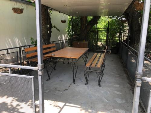 een houten tafel en banken op een patio bij Драхтик in Jerevan